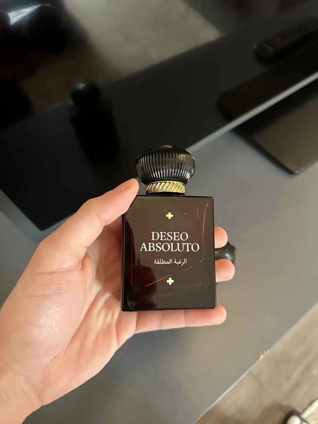 Fotografía de la tienda: nuevo frasco de Deseo Absoluto sostenido en una mano